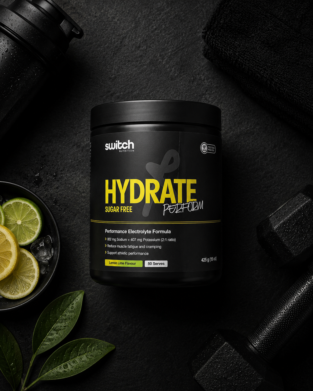 Hydrate powder container with switch brand on a dark background with gym equipment and fruits.