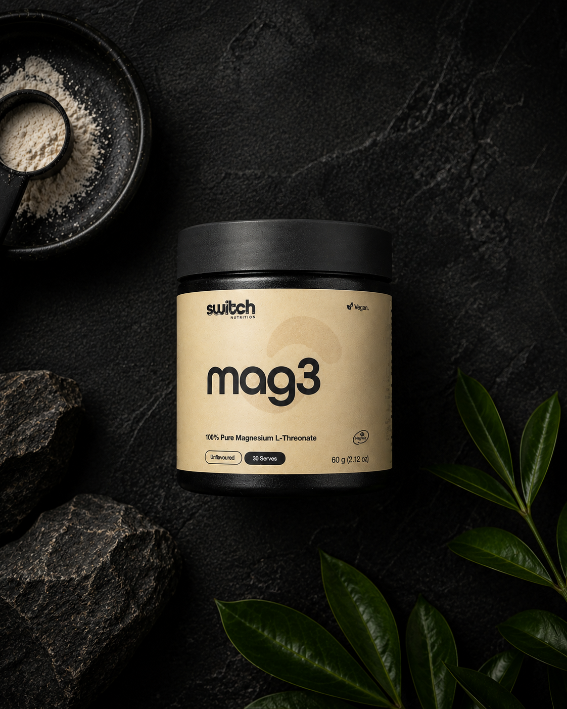 Container of switch Nutrition mag3 supplement on a dark background with leaves and rocks.