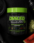 Container of Dialed Shred supplement with watermelon flavor on a black background