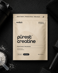 Package of 'purest creatine' with a shaker and scoop on a dark background