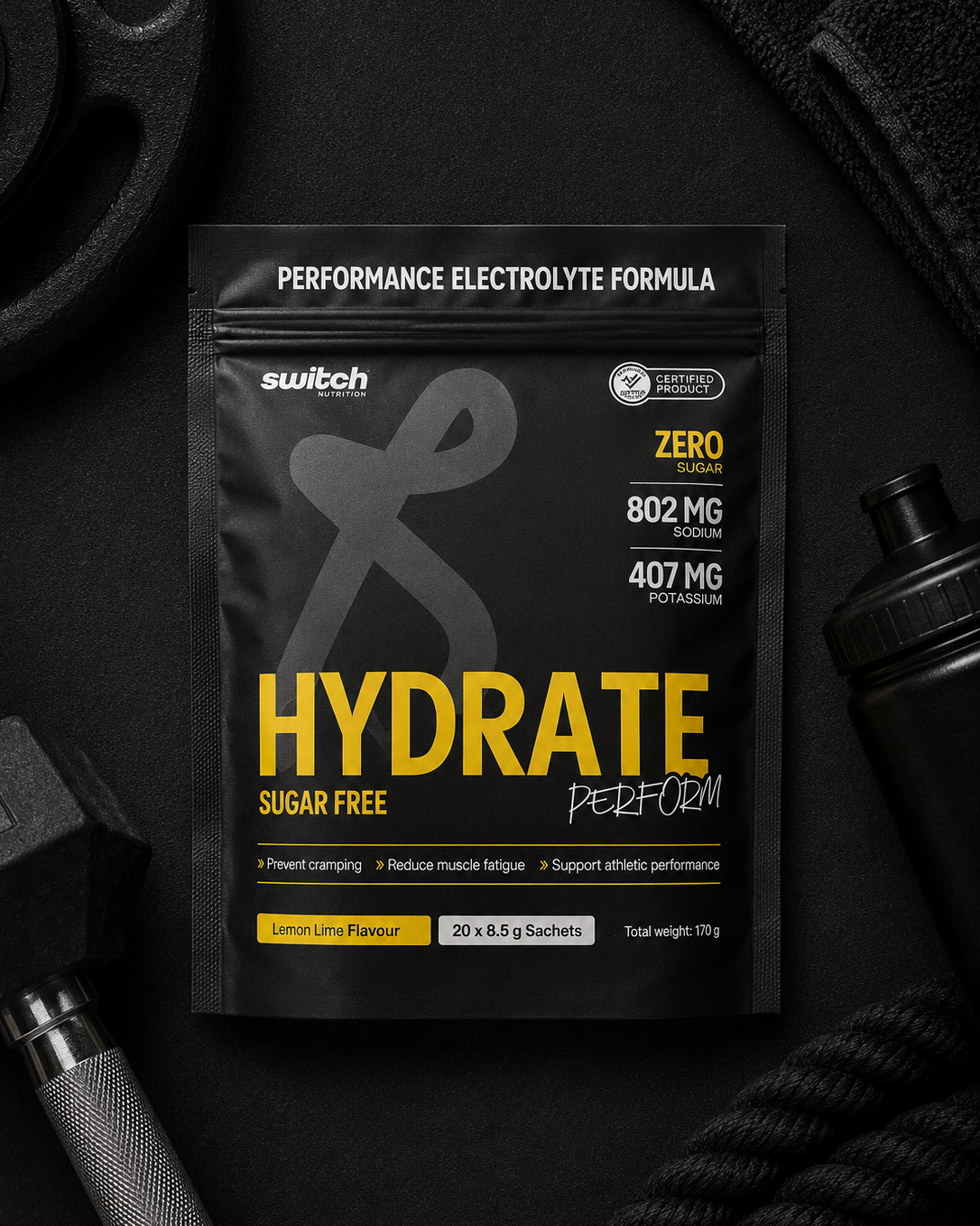 Black and yellow supplement package labeled 'Hydrate' on a dark background with fitness equipment.