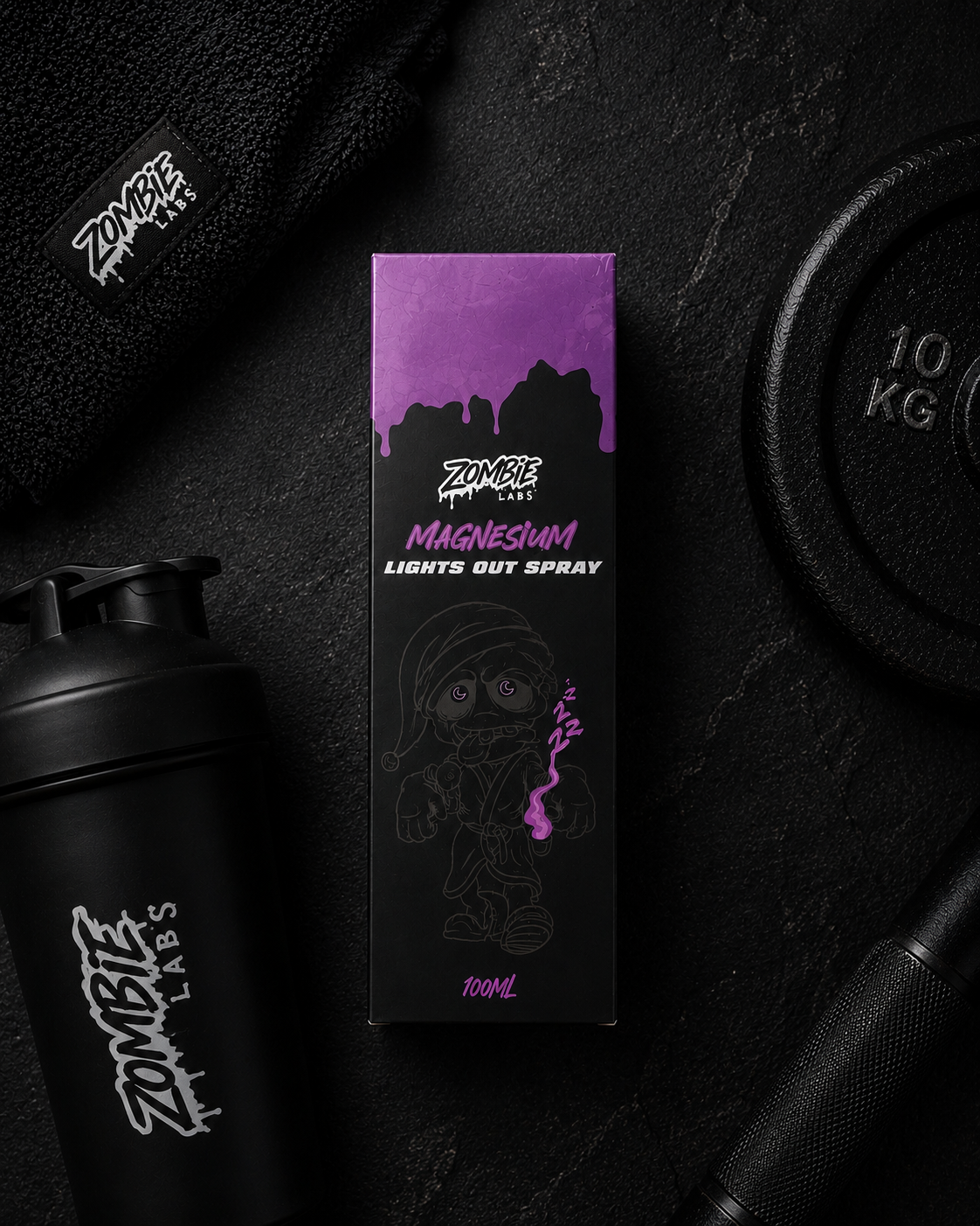 Zombie Labs Magnum Lights Out Spray packaging on a dark background with gym equipment.