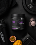 Multivitamin supplement container labeled 'Multi-Mag' on a dark surface with fitness equipment and fruits.