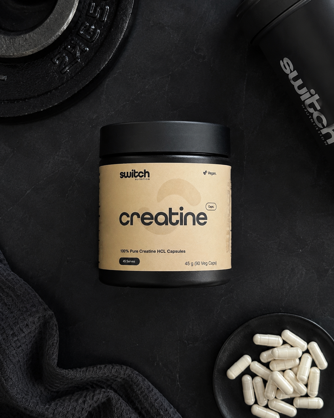 Container of switch creatine on a black surface with additional creatine capsules.