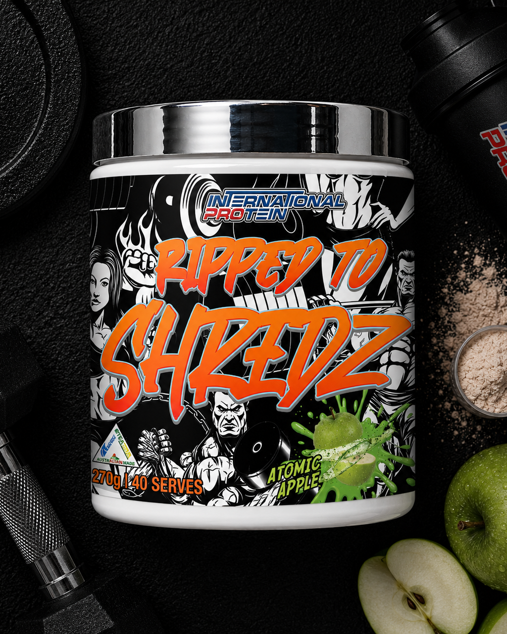 International Protein Ripped to Shredz supplement container with gym equipment and apples in the background