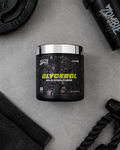 A black tub of Spire Labs Glycerol 69% Glycerol Powder with a shiny silver lid, styled on a gray concrete background with gym accessories like a shaker bottle, weight plate, and resistance bands.