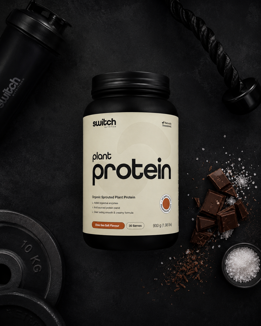 Switch plant protein container on a dark background with gym equipment.