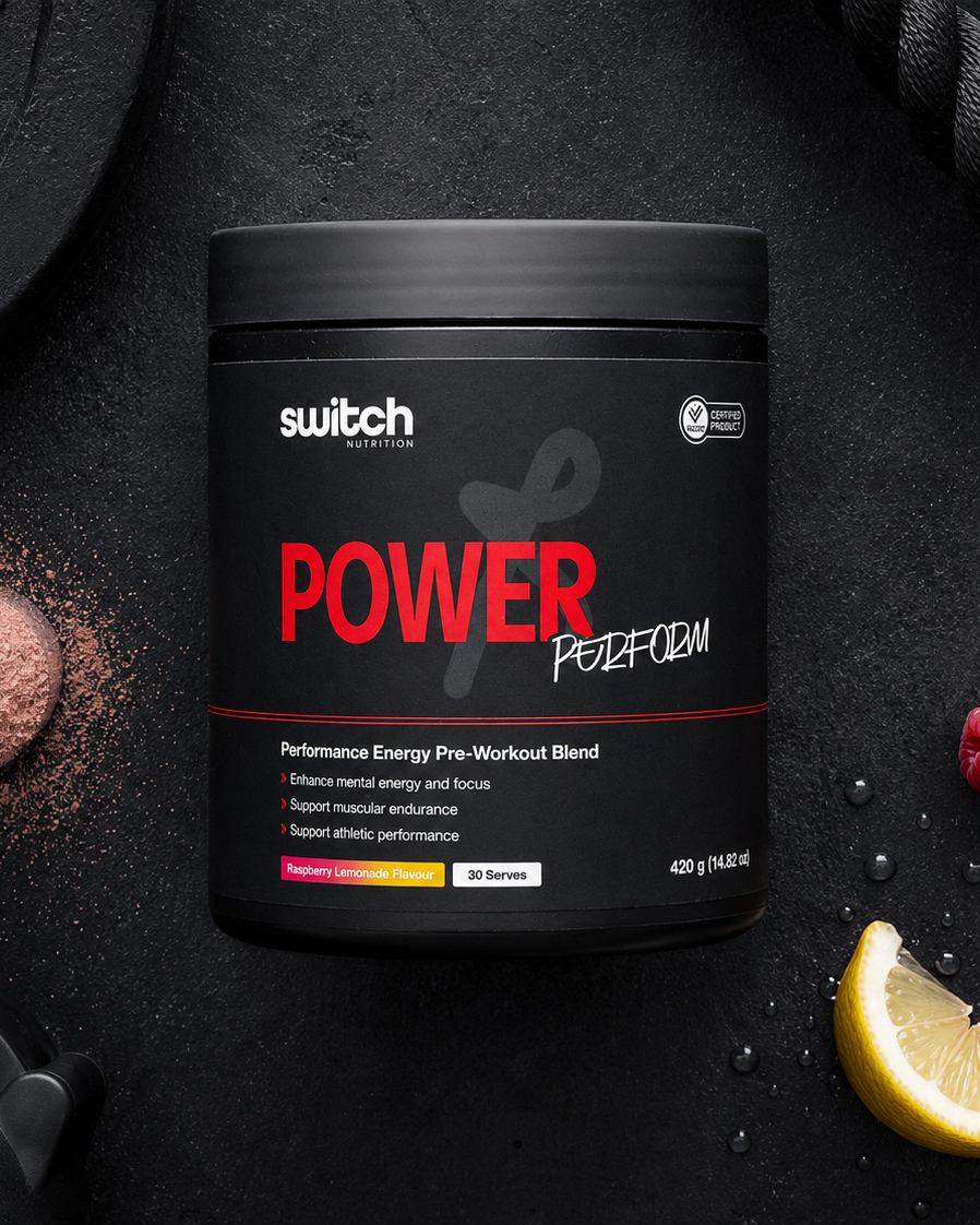 Container of 'switch' Power Perform pre-workout supplement on a dark surface with gym equipment and berries.