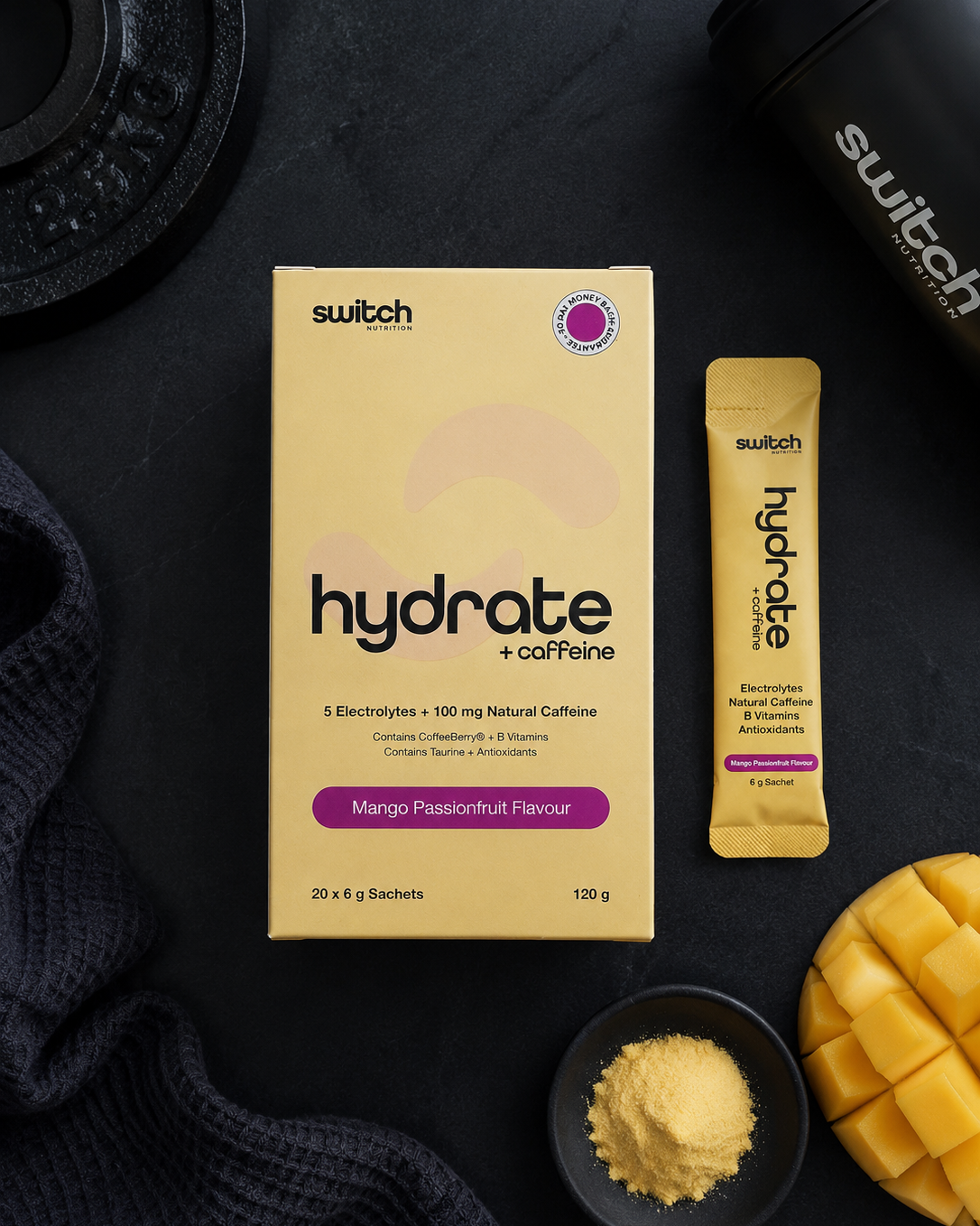 Switch Hydrate + Caffeine packaging with mango and a shaker on a dark surface